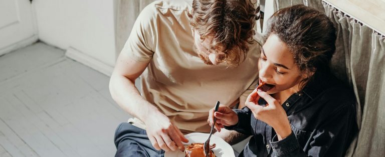 two lovers eating together from the same plate