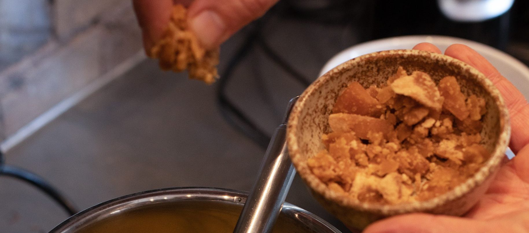 Turmeric pot held in hand in preparation for golden milk