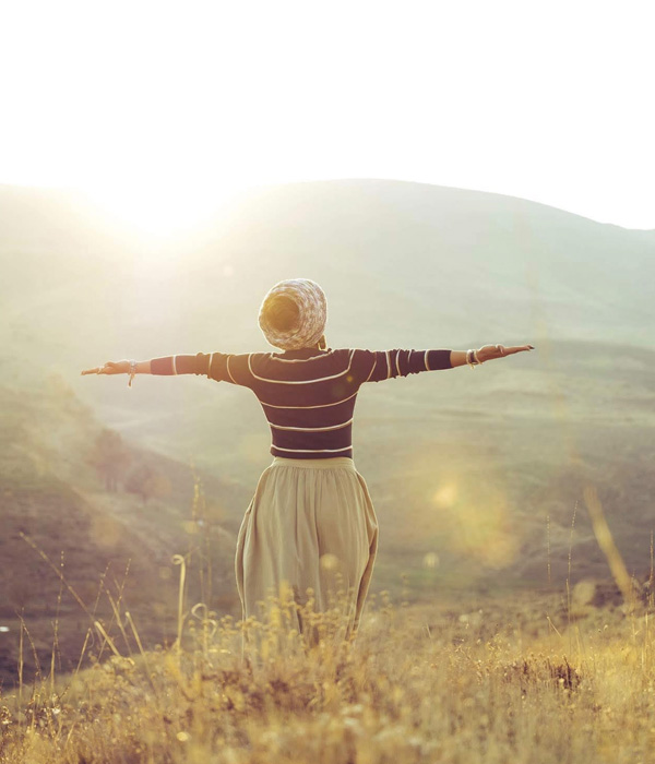 woman holding arms out greeting nature