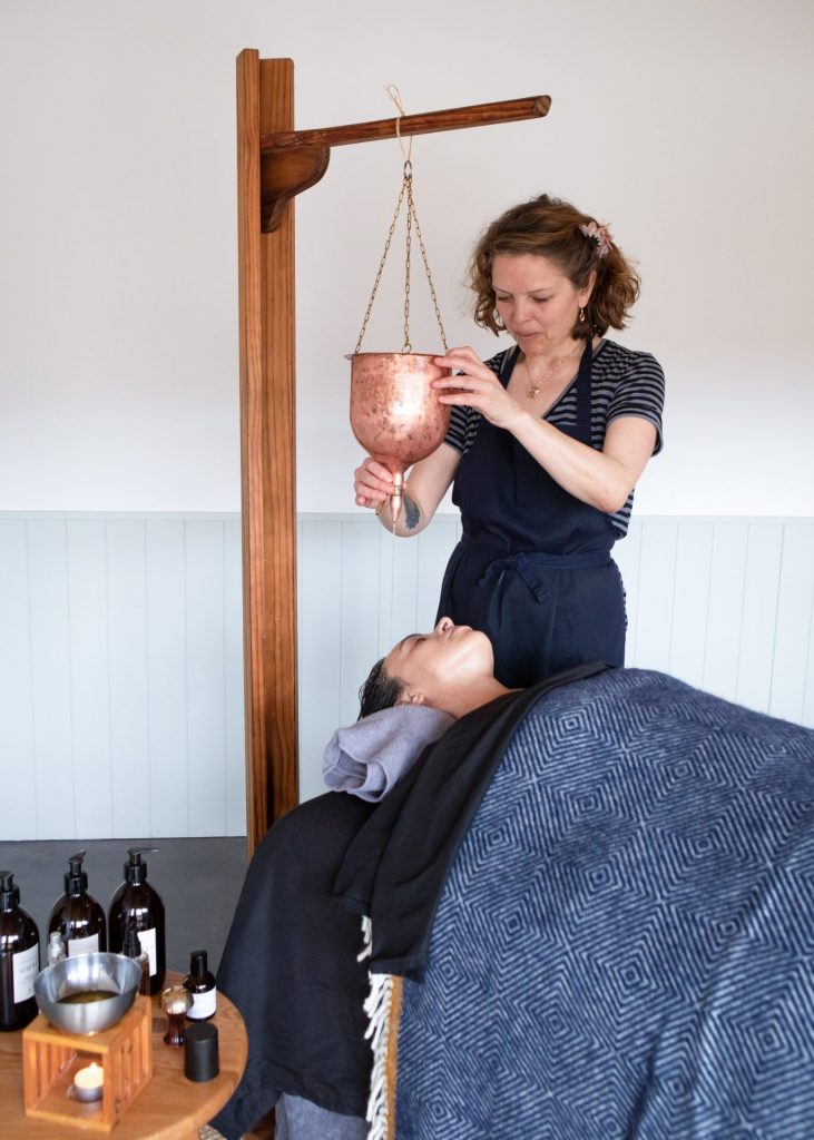 Anu Paavola, Ayurvedic practitioner, giving a shirodhara and Indian head massage at her ayurveda retreat in Dorset UK.